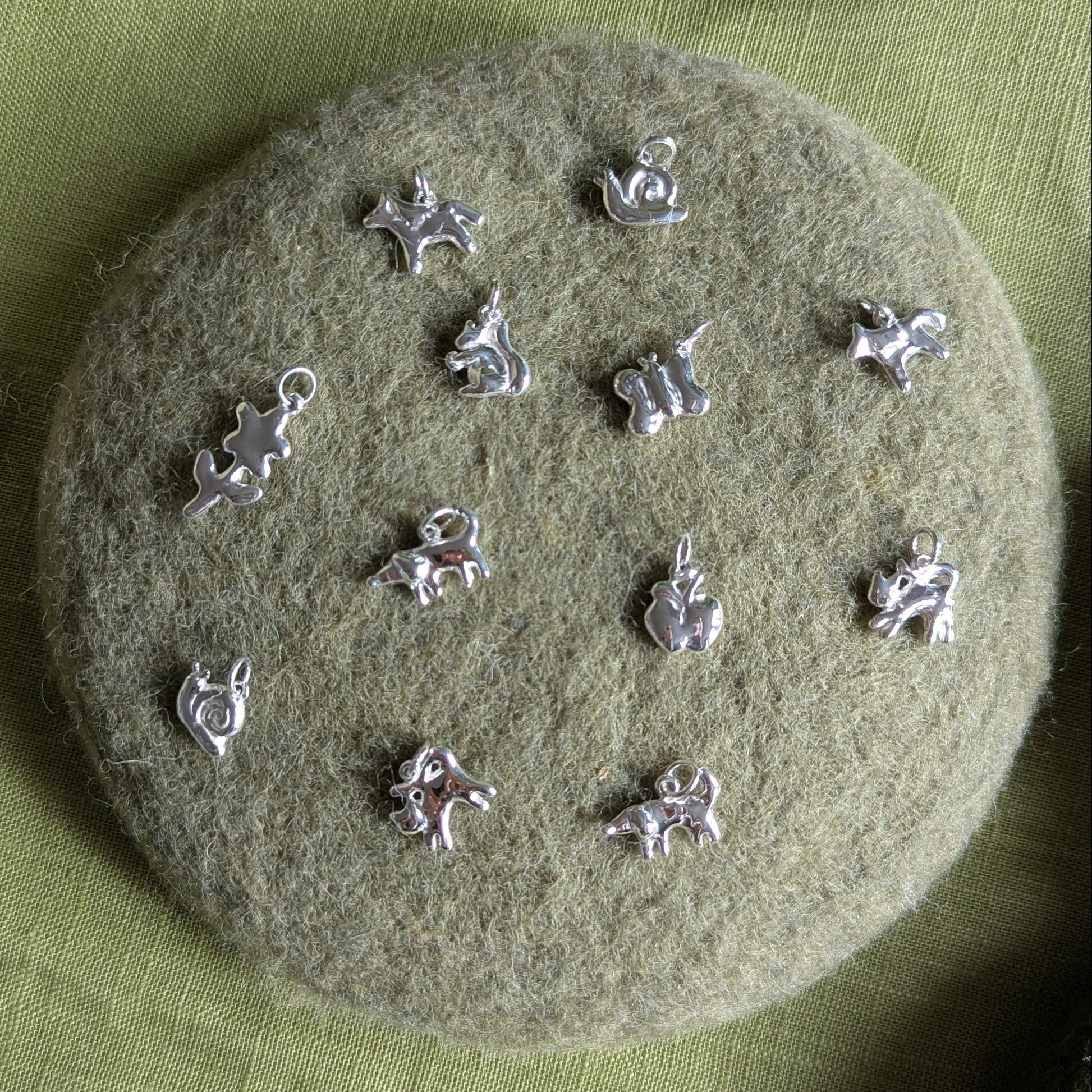 Silver charms on a textured green surface