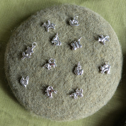 Silver charms on a textured green surface